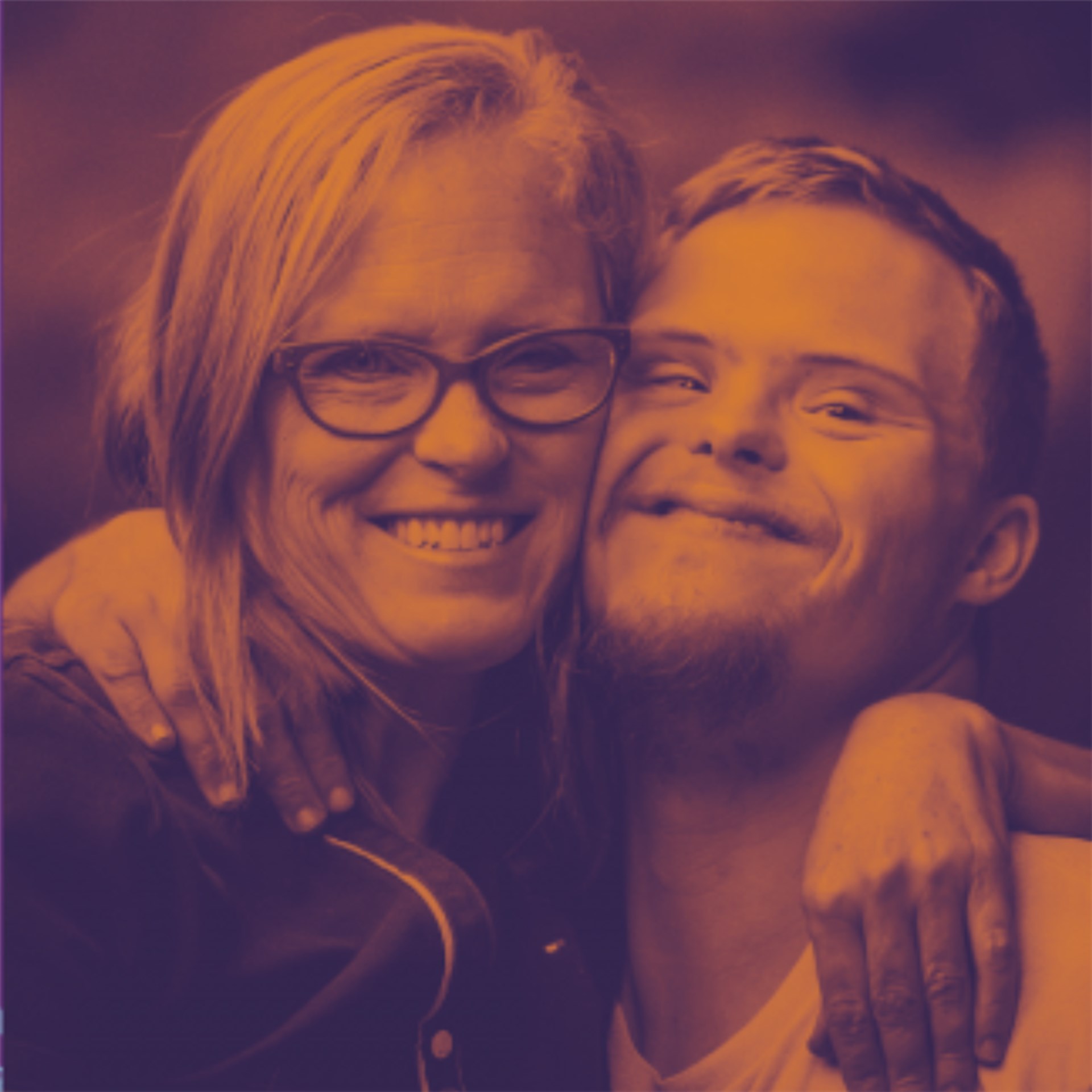 Eine Frau und ein Junge mit Down-Syndrom umarmen sich und gucken in die Kamera. Das Bild ist orange unterlegt. 